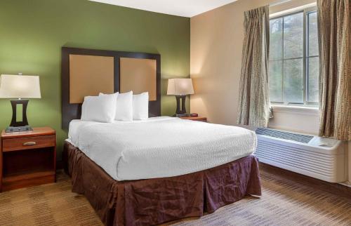 a hotel room with a large bed and a window at Extended Stay America Suites - Raleigh - North Raleigh - Wake Towne Dr in Raleigh