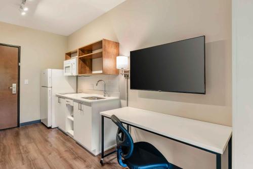 a kitchen with a desk and a tv on the wall at Extended Stay America Premier Suites - Charlottesville in Charlottesville