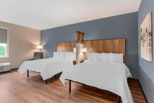 two beds in a room with blue walls at Extended Stay America Premier Suites - Charlottesville in Charlottesville