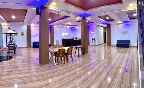 a ballroom with a table and chairs and purple lights at Riltree hotel in Bulukumba