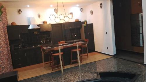 a kitchen with a counter and a table and chairs at Le Chacal in Foumban