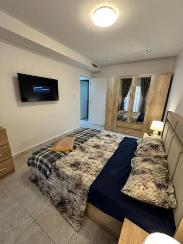 a bedroom with a large bed and a flat screen tv at residence nid d'abeille in Bejaïa