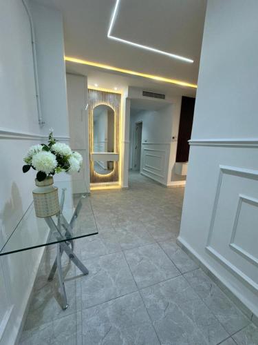a room with a glass table with a vase of flowers at residence nid d'abeille in Bejaïa