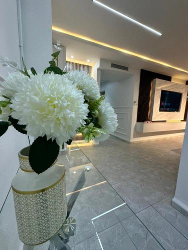 a vase filled with white flowers in a room at residence nid d'abeille in Bejaïa