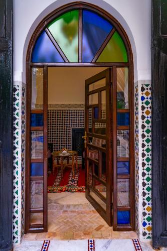 an open door to a room with a stained glass window at Riad Dar Dialkoum in Marrakech