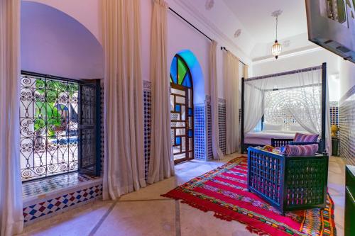 a living room with a large window and a door at Riad Dar Dialkoum in Marrakech