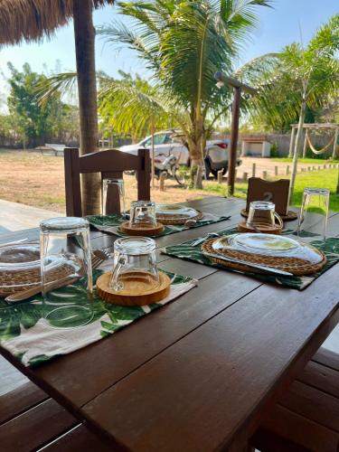a wooden table with plates and glasses on it at The Jungle, Village & Beach in Guriú