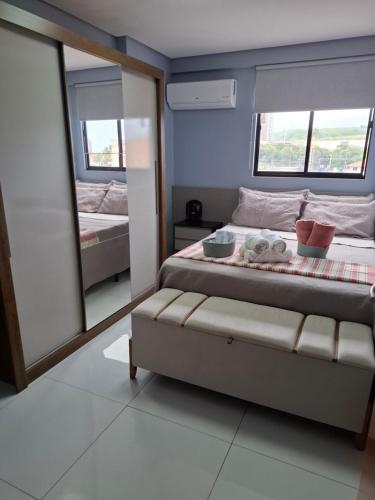 a bedroom with a bed and a mirror at Smart Residence Praia in Maceió
