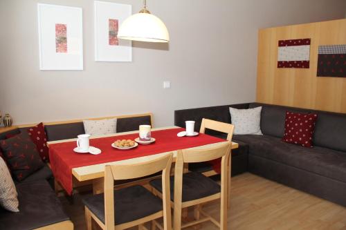 a dining room with a table and a couch at Alpina Residence in Solda