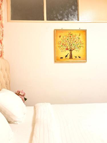 a bedroom with a picture of a tree on the wall at Peaceful and Spacious Apartment at Luanda Bay in Luanda