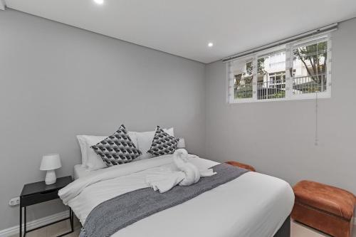 a white bedroom with a bed with towels on it at Walk to Beach, Fast WiFi, Discounted, Nightlife in Kirstenhof