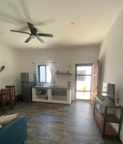 a living room with a ceiling fan and a refrigerator at Casa Loto D in Chelem