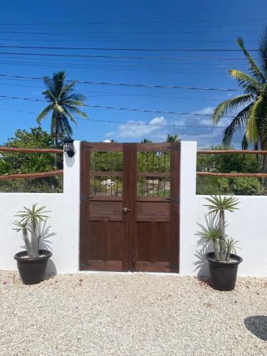 a wooden gate with two potted plants in front of it at Casa Loto D in Chelem