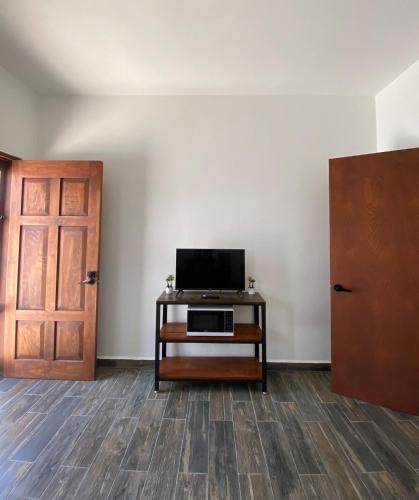 a room with a door and a television on a table at Casa Loto D in Chelem