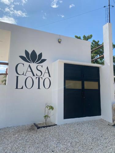a white building with a csa loto sign on it at Casa Loto D in Chelem