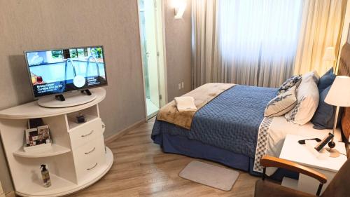 a bedroom with a bed and a television on a stand at GRU Airport Hotel - STAY HERE in Guarulhos