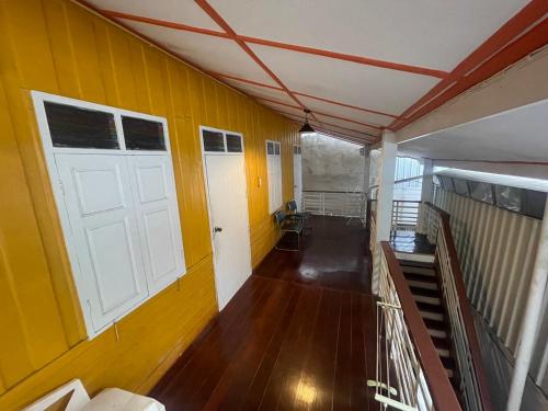 an empty room with a white door and yellow walls at Thai-Tae Guesthouse Hua Hin in Hua Hin
