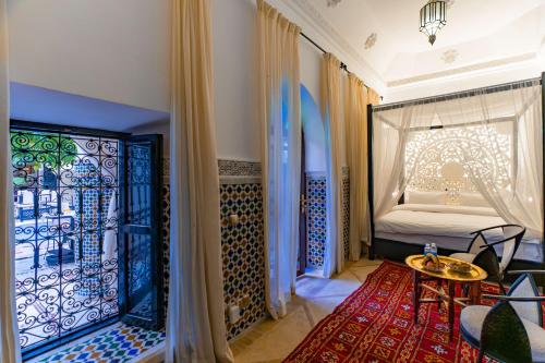 a room with a table and a bed with a window at Riad Dar Dialkoum in Marrakech