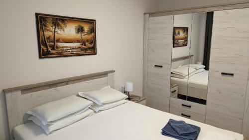 a bedroom with a white bed and a large mirror at Well Equipped New Family Friendly One-Bedroom Flat in Sandanski