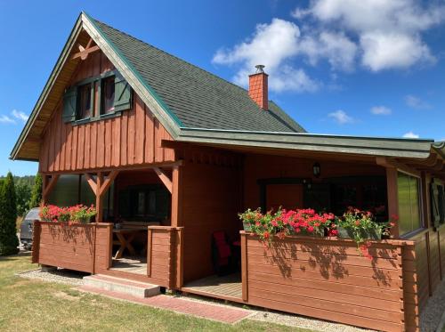 a house with two flower boxes in front of it at Bałtycka Oaza in Debina