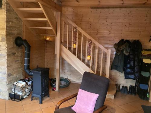 a room with a stairs and a chair and a stove at Bałtycka Oaza in Debina