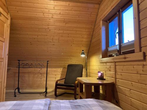 a bedroom with a bed and a chair and a table at Bałtycka Oaza in Debina