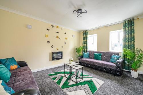 a living room with a couch and a clock on the wall at H17A Cosy & Welcoming home in Liversedge