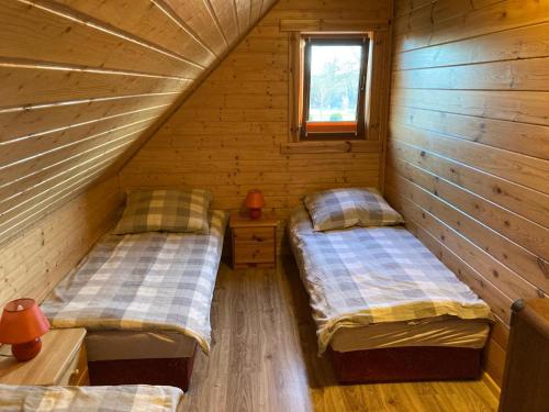 a room with two beds in a log cabin at Bałtycka Oaza in Debina