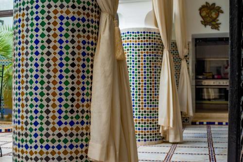 a display of curtains in a room with colorful tiles at Riad Dar Dialkoum in Marrakech