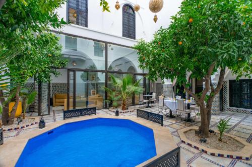 a large swimming pool in a courtyard with trees at Riad Dar Dialkoum in Marrakech