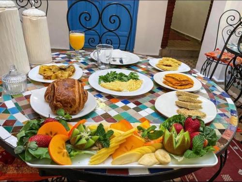 Una mesa con platos de comida sobre una mesa. en Riad merzg, en Fez