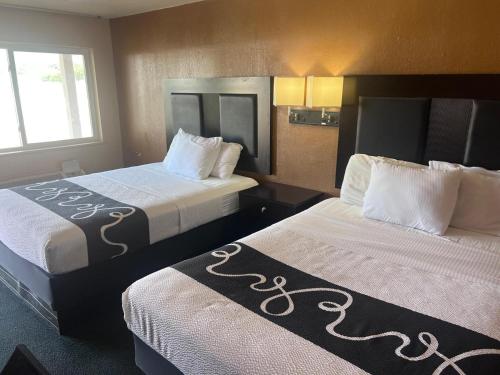 a hotel room with two beds and a window at Antlers Inn in Falfurrias
