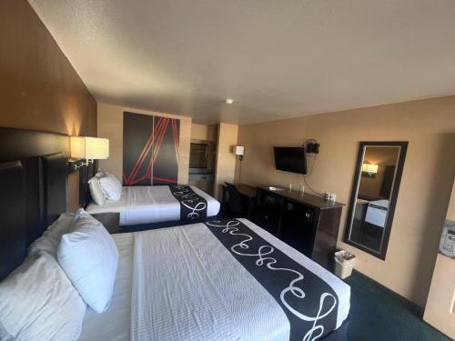 a hotel room with two beds and a television at Antlers Inn in Falfurrias