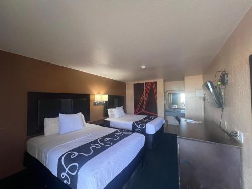 a hotel room with two beds and a television at Antlers Inn in Falfurrias