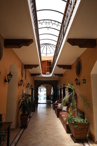 a hallway with plants in a building with a skylight at Hotel Casa del Virrey & Suites in Morelia
