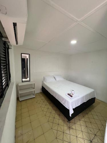 a bedroom with a bed in a white room at Hostal Valle in Valledupar