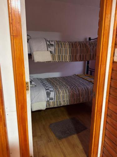 Una habitación con dos literas y una puerta abierta. en Cabaña en Curacautin, en Curacautín