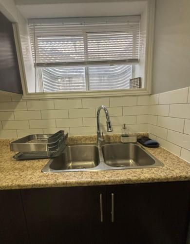 a kitchen counter with two sinks and a window at Fully Furnished 2 Bedroom Apartment in Kitchener