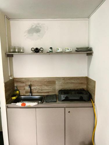 a small kitchen with a sink and a stove at Aparta Estudio Confortable, Lujoso y Comodo en Milan in Manizales