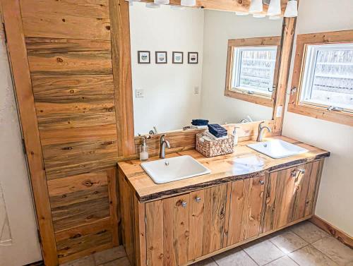 a bathroom with two sinks and a wooden wall at 3BR - Near Mt Massive & Mt Sherman Escape in Leadville