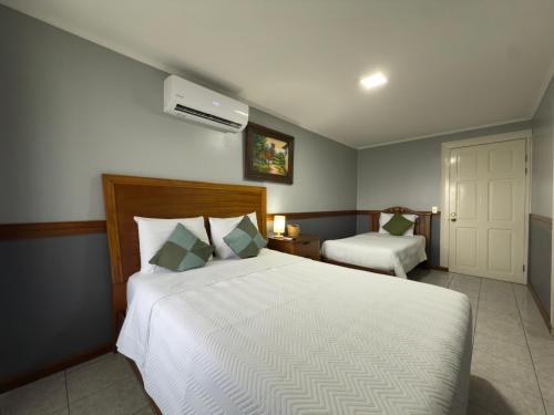 a bedroom with a large white bed and a window at Stada San Jose Airport Hotel in Alajuela City