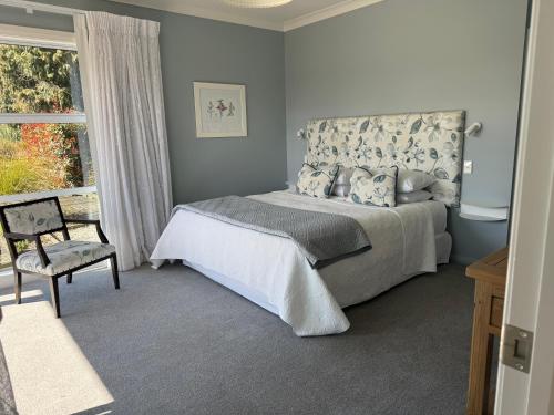 アシュバートンにあるRevive On Oakview Boutique Beauty and Accommodationのベッドと椅子と窓のある寝室
