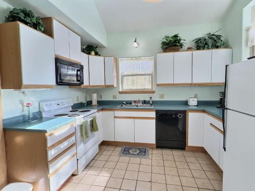 een keuken met witte kasten en zwarte apparaten bij 2 Bed Cabin Fireplace Lodgepole Pines in Leadville