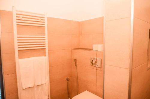a bathroom with a shower with a toilet and a towel at Beach Club Bungalow Induruwa in Induruwa