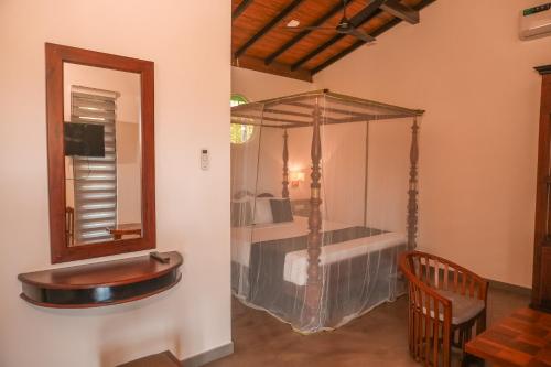 a bathroom with a tub with a mirror and a sink at Beach Club Bungalow Induruwa in Induruwa