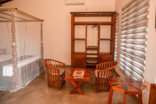 a living room with a table and chairs and a mirror at Beach Club Bungalow Induruwa in Induruwa