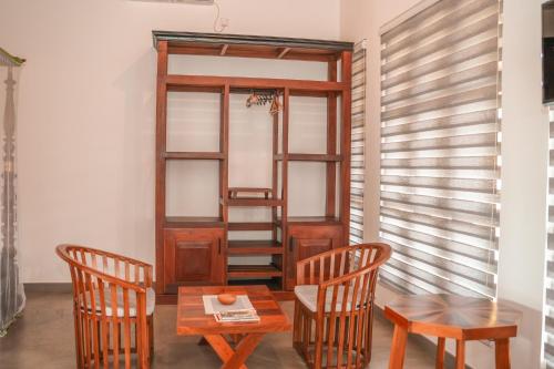 a dining room with a table and chairs and a shelf at Beach Club Bungalow Induruwa in Induruwa