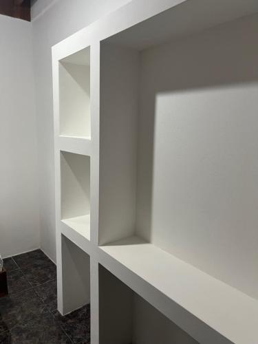 a white shelf in the corner of a room at Woodstock Hostel in Sámara