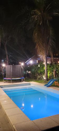 ein leerer Swimmingpool in der Nacht mit Palmen in der Unterkunft Che Kerecha- Casa quinta in Riachuelo