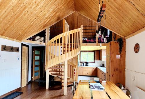 a room with a wooden staircase in a house at Chalet L'Apéro des Chutes - Spa, détente & nature au bord de l'eau en Mauricie in  Notre-Dame de Montauban